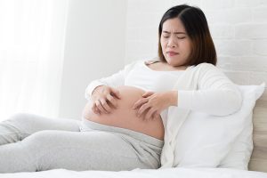 A pregnant woman having some mild pain on her stomach.