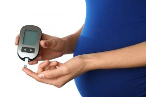 A pregnant woman testing her blood sugar level.