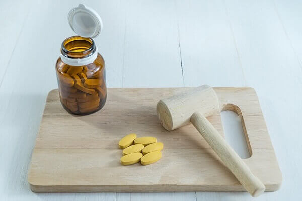 pills in a jar on a cutting board